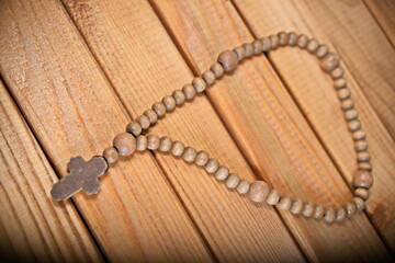 wooden rosary on wooden background