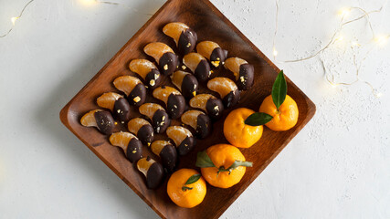 Tangerine background. Chocolate-covered tangerine slices. Top view. 