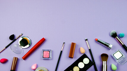 lots of makeup on a purple background with space for writing