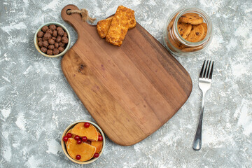 Breafast background with chocolate cookies in a glass jar sweets cutting board on blue background