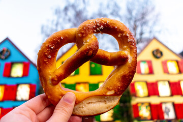 Closeup of a pretzel with the background of colored houses from Turckheim in Alsace