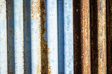 Rusted corrugated sheet metal siding background showing its age and weathering.