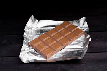 Bar of chocolate on wooden background