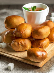 baked pastries with tea on wooden background