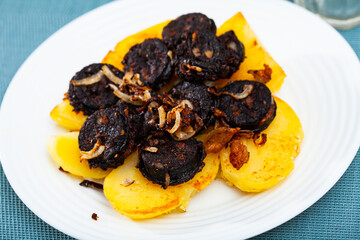 Delicious Catalan blood sausage with rice with garnish of baked potatoes..