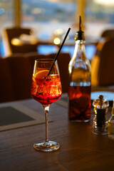 Close upof a glass with ice and orange coctail in restaurant.