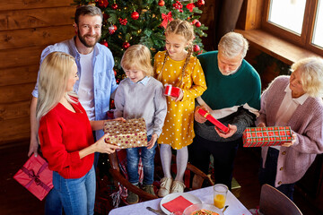 family exchanging gifts for christmas, happy members of caucasian big family please each other
