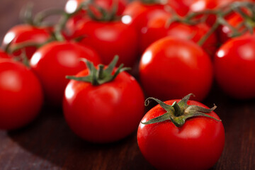 Closeup of fresh ripe tomatoes on wooden surface. Organic vegetables concept