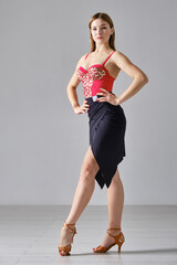 Attractive girl dances ballroom dancing in front of a mirror in a bright white hall. A professional...