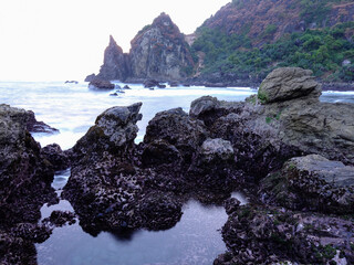 Black coral formation at dusk at Watulumbung Beach, Yogyakarta, Indonesia. Combined with the slow speed technique, this beach is a favorite spot for landscape photographers.