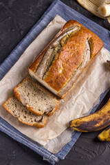 A traditional American dish is gluten and dairy free banana bread on a black concrete background. Top view, copy space.