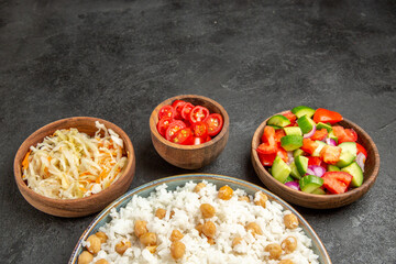 Peas and rice for dinner and sauerkraut and chopped tomato with salad on dark background