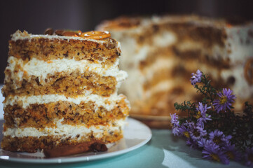 Carrot cake with nuts, prunes and dried apricots . Purple flowers, bouquet.