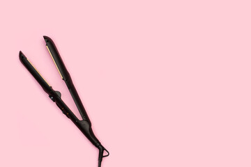 Plancha de pelo sobre un fondo rosa liso y aislado. Vista superior. Copy space. Concepto: Cuidado...