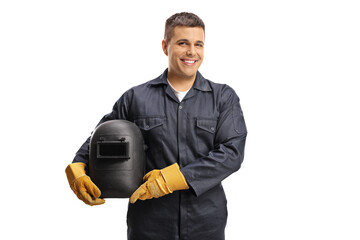 Young cheerful welder in a uniform holding a protective helmet