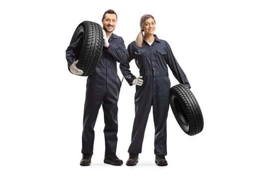 Male And Female Auto Mechanic Workers Carrying Car Tires