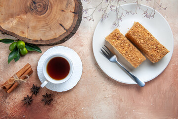 top view tasty cake slices with cup of tea on a light background sweet biscuit cake pie