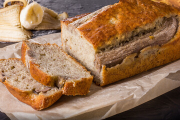 A traditional American dish is gluten and dairy free banana bread on a black concrete background. Top view, copy space.