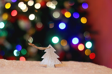 Wooden Christmas tree decoration. Selective focus, colorful bokeh.