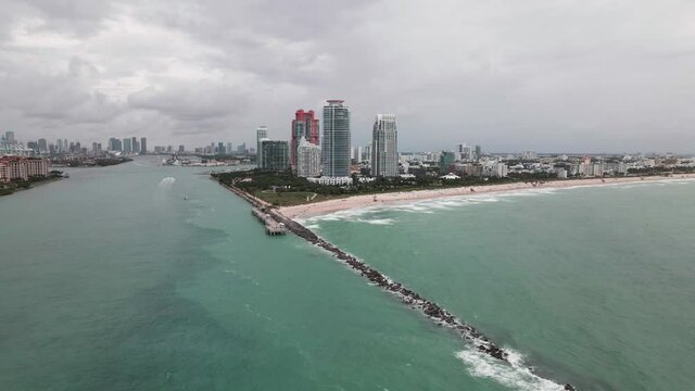 Aerial footage of Miami South Beach and South Pointe Park Pier on cloody day. Drone side shot.