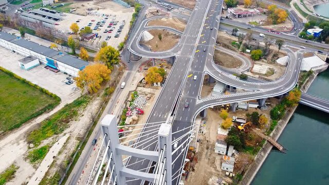 Ciurel passage, bridge over a river with moving cars, construction works near it. View from the drone. Bucharest, Romania