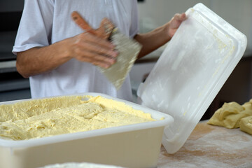 Baker preparing dough of bread for baking at the bakery