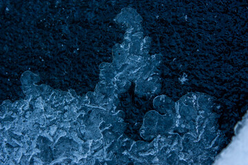 Winter background. Fantastic ice patterns on the surface of frozen water.