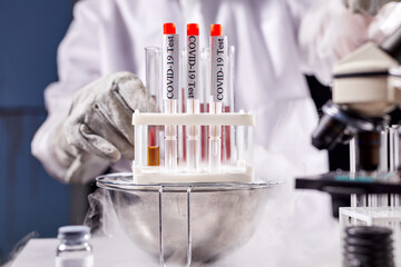 professional researcher is doing experiment with smoke on a table of a chemical laboratory, using test coronavirus tubes, conduct scientific experiment