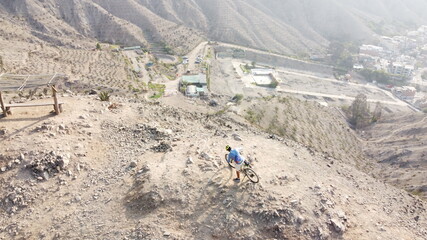 Man riding mountain bikes along the barren rocky terrain.