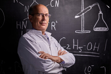 intelligent professor chemist man posing at camera, smiling. standing with crossed arms. professor...