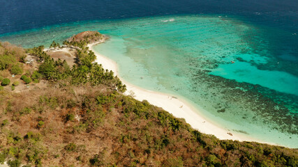 Fototapeta na wymiar aerial view sandy beach on tropical island with palm trees and clear blue water. Malcapuya, Philippines, Palawan. Tropical landscape with blue lagoon, coral reef