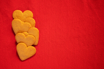 Obraz premium Happy valentine's day, heart shaped gingerbread cookie on red background with copy space