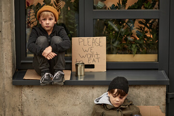 abandoned caucasian kids in city streets, ask for money and help, poor and dirty without home