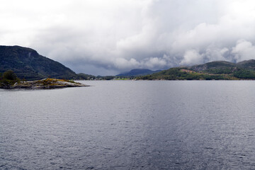 Norwegian fjord, mountains, rustic houses on the coast. Natural rural landscape view, Norway. A...