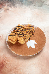 Vertical view of tasty desserts decorated with chocolate syrop for a person on colourful table