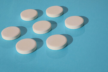 Top view mock-up of white rounded drugs isolated on blue background. 