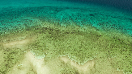 Sea water surface in lagoon and coral reef, copy space for text, aerial view.Top view transparent turquoise ocean water surface. background texture