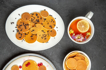 top view yummy pancakes with cup of tea on the dark background sweet pie dessert cake