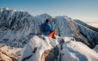 Hiker or Alpinist overlooking winter peaks like moutains landscape of High Tatras, Slovakia. Concept: Adventure, Explore, Hike, Lifestyle. Composite.