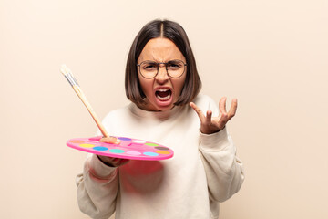 young hispanic woman looking angry, annoyed and frustrated screaming wtf or what’s wrong with you