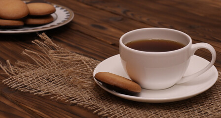 White cup of coffee and cookies on wooden table. Coffee time concept.
