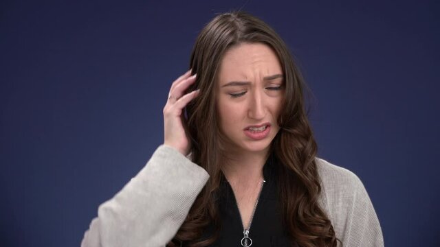 Lovely young woman confused and  bewildered scratches her head