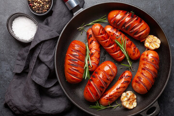 Hot grilled sausages in a frying pan