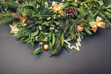 Christmas and New Year decoration made of fir, pine, mistletoe branches, cones with golden ornaments, toys. Space