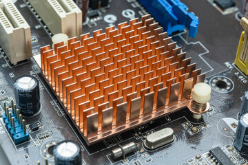 Close up view of copper heat sink or radiator on computer motherboard.