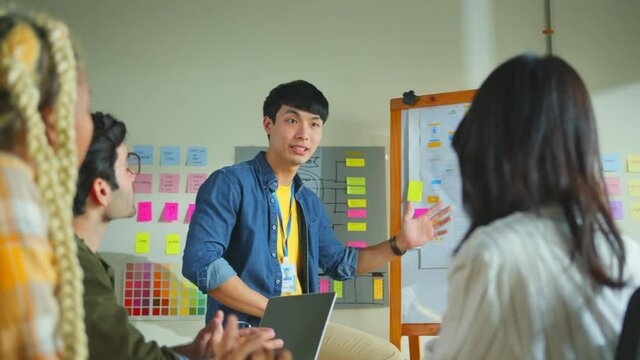 Meeting of UX developer and UI designer brainstorming about mobile app interface workflow design on table with coworker breif and color code at co-working space.Creative digital development agency.