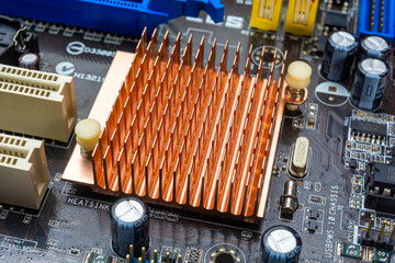 Close up view of copper heat sink or radiator on computer motherboard.