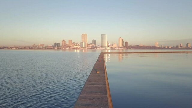 Milwaukee Wisconsin skyline during a beautiful clear sunrise with low angle perspective of Lake Michigan, establishing shot.