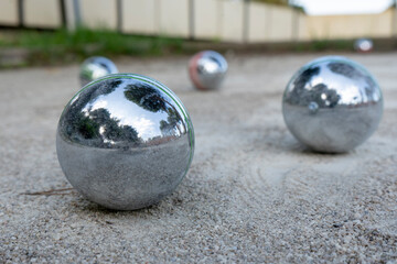 Close-up of steel balls for petanque on a gravel surface, France. Selective focus