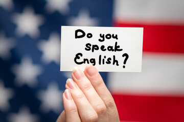 Do you speak English text on a card. American flag background.